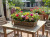 Kosz rattanowy Willow z kwiatami na tarasie lub w ogrodzie – naturalny styl Solani Home